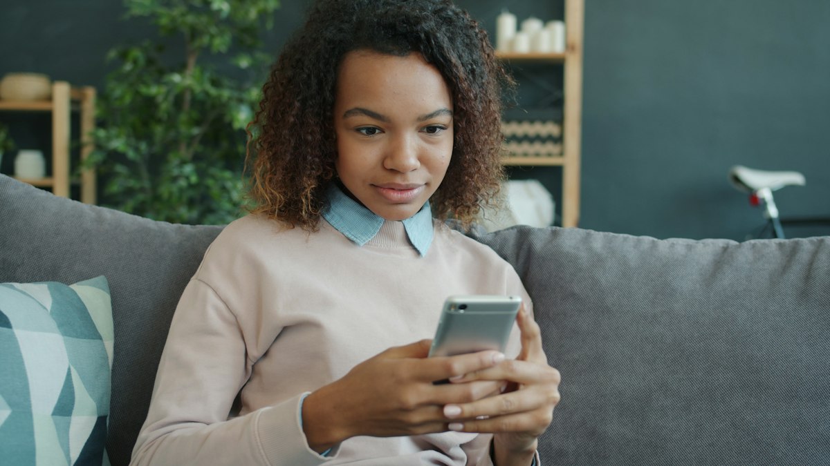A person using a smartphone while sitting on a sofa