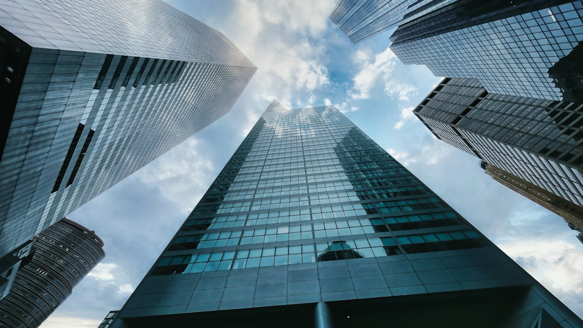 Low angle photography of high rise building under white clouds during daytime