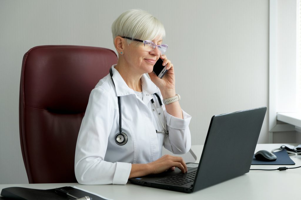 woman-doctor-talking-phone-doctor-s-office-consults-patient